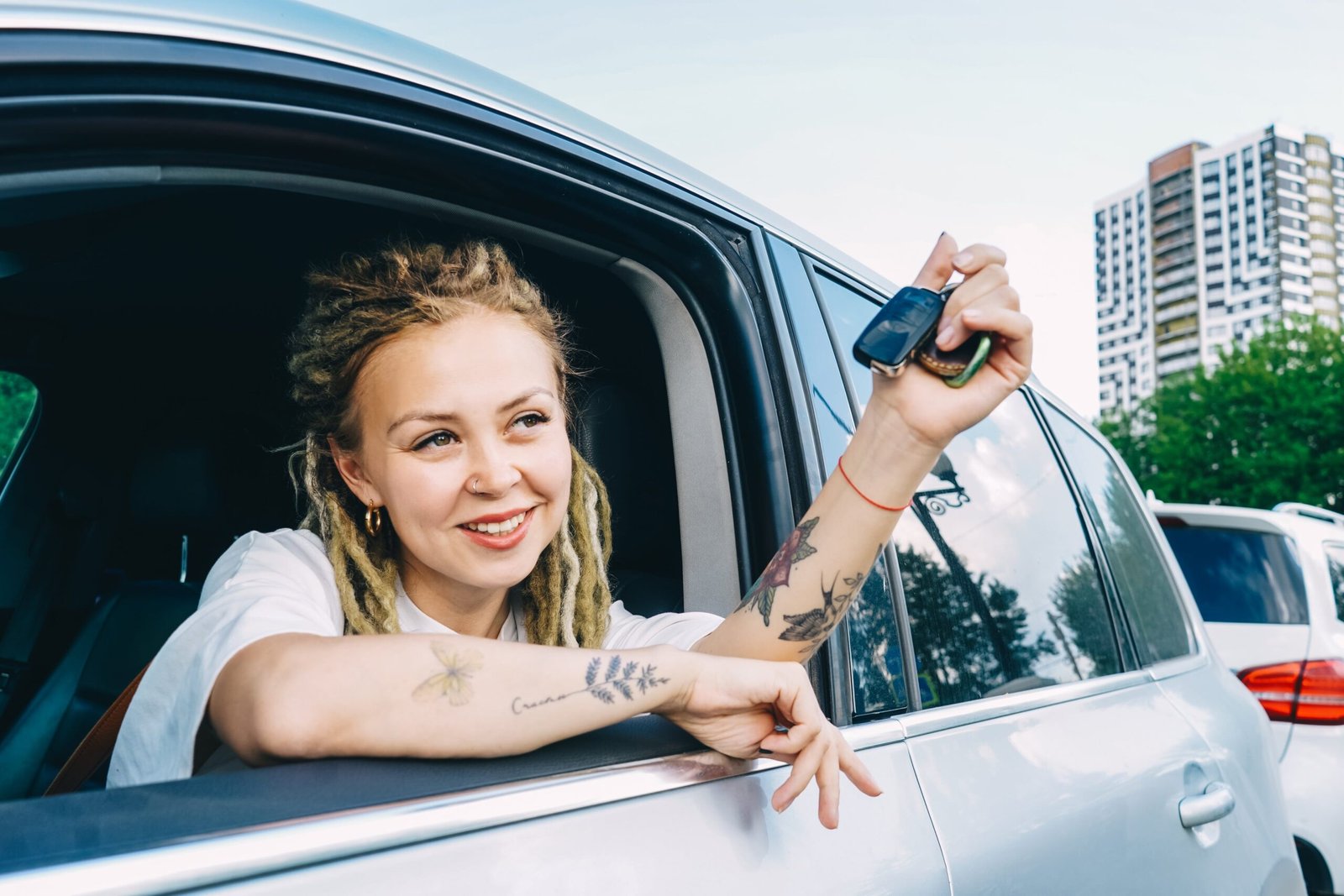 happy-smiling-woman-with-car-key-driving